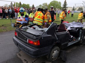 Firefighters remove a patient during a mock car crash demonstration at St. Cecilia Junior High School on Wednesday. Perry Mah/Edmonton Sun