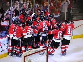 Chicago Blackhawks players mob Michal Handzus after scoring the double-overtime winner against the Los Angeles Kings in Game 5 of the NHL Western Conference final at the United Center in Chicago, May 28, 2014. (DAVID BANKS/USA Today)
