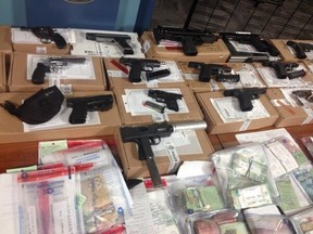 Drugs, weapons and cash - seized in raids related to Projects Rx and Battery - on display at Toronto Police headquarters. (JACK BOLAND/Toronto Sun)