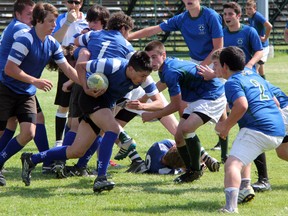 Deon Wrightman of SCITS (with the ball) tries to plunge through a line of St.Patrick's Fighting Irish defenders during their LSSAA junior boys rugby championship match on Thursday, May 29. St. Pat's prevented Wrightman from scoring not only on the play, but stopped the BlueBombers from finding the end-zone at all during the game. The Irish won the LSSAA title 19-0 . SHAUN BISSON/ THE OBSERVER/ QMI AGENCY