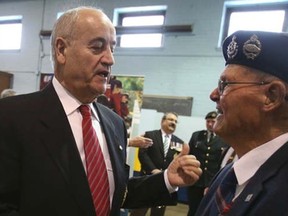 The Honourable Julian Fantino (L) Minister of Veterans Affairs shakes hands with 94-year-old veteran Russell Smith, of Oshawa, on Sunday March 2, 2014. Jack Boland/QMI Agency