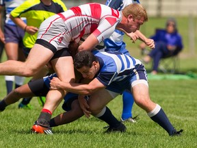 Dillon Goos, of Medway, is tackled short of the goal line by two Lucas players during their WOSSA final at St. George?s fields in London on Thursday. Medway won 31-8 after leading 17-3 at the half. (Mike Hensen/The London Free Press)