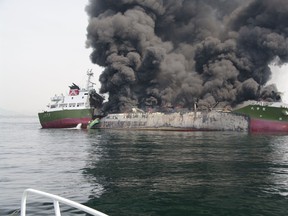 This handout picture taken and released by Japan's Coast Guard on May 29, 2014 shows black smoke rising from a 998-tonne oil tanker off the coast of Hyogo prefecture, around 450 kilometres west of Tokyo. (AFP PHOTO / JAPAN COAST GUARD)