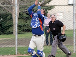 The Mets Brandon Strocki, who is proving to be a valuable commodity as a utility player, settles in under a foul ball during his team’s big win over St. Albert. Plate umpire Paul Riopel moves into position to make the call. - Gord Montgomery, Reporter/Examiner