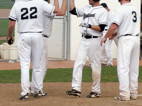 Aaron Dunsmore is greeted at home by his teammates after his first homer of the night, a three-run shot over the left field fence. He followed that up in his next at-bat with a two-run shot. - Gord Montgomery, Reporter/Examiner