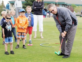 Under the watchful eyes of his students, Stony’s head golf pro Gary Christenson demonstrates how the club, known as the launcher, works. - Gord Montgomery, Reporter/Examiner