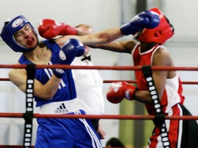Nicholas Bernard (blue shirt) from The Boxing Club trades blows with Ramze Abduraheman, but appears to come away with the worst of the exchange, during their bout at the Al Harris Memorial Card, held in Stony on May 24. - Gord Montgomery, Reporter/Examiner
