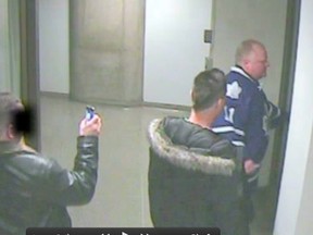 Rob Ford is seen returning to City Hall after an April Maple Leafs game with two men in this still from security footage.