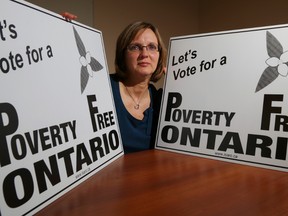 Ruth Ingersoll holds Poverty Free Ontario signs Friday at the Community Development Council of Quinte office in Belleville. The signs are for sale and the agency encourages voters to question Ontario election candidates about poverty-related social issues.