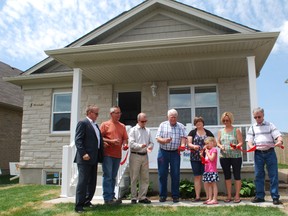 Habitat for Humanity dedicated its first-ever house in St. Thomas with a brief ceremony on Friday. Cutting the ribbon in front of the home were Habitat for Humanity Heartland Ontario CEO Jeff Duncan, left, volunteer Rick Wray, Habitat past chairman Phil Squire, developer Dick Greenway, homeowner Diane Doucet and daughter Aimee-Lynn Sim, volunteer Joanne Dowsell and Elgin county Warden David Marr. (Ben Forrest, Times-Journal)