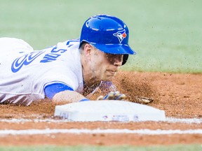 Toronto Blue Jays' baserunner Steve Tolleson dives back to first base during the fourth inning against the Kansas City Royals at the Rogers Centre in Toronto, Ont. on Friday May 30, 2014. (Ernest Doroszuk/Toronto Sun/QMI Agency)