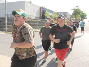 A Grade 9 physical education class from Sydenham High School passes the new addition as they head out on their marathon project Tuesday morning. Students at the school were trying to run the equivalent of as many marathons as possible during the month of May. (Michael Lea/The Whig-Standard)