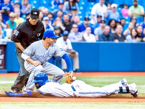 Blue Jays' Jose Reyes slides in with a leadoff triple under Royals' Danny Valencia's tag on Friday night. Reyes was left stranded at third as the Jays failed to score. (Ernest Doroszuk/Toronto Sun)