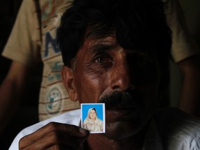 Muhammed Iqbal, 45, shows a picture of his late wife Farzana Iqbal, at his residence in a village in Moza Sial, west of Lahore May 30, 2014. REUTERS/Mohsin Raza