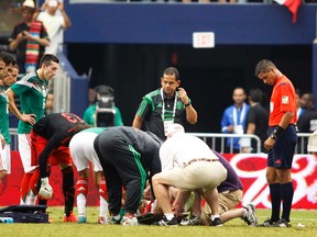 Team personnel attend to Mexico midfielder Luis Montes after he was injured during a friendly against Ecuador at AT&T Stadium in Arlington, Tex., May 31, 2014. (MIKE STONE/Reuters)