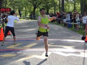 Michigan's Mattew Fecht stumbles across the finish line of the 37th YMCA International Bridge Race on the morning of Sunday, June 1. Fecht was the race's first finisher by well over two minutes with a time of 30:04.5. SHAUN BISSON/ THE OBSERVER/ QMI AGENCY