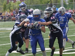 Sudbury Junior Gladiators' Darcy Labelle fights off a pair of Oakville Titans tacklers during football action at James Jerome Sports Complex on Saturday.
