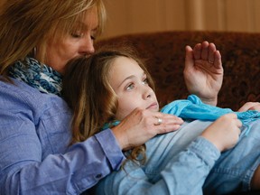 Madi Vanstone lays with her mother, Beth, at their home outside Beeton. Madi has cystic fibrosis and Beth pounds her chest and back for over 35 minutes, twice each day. (Stan Behal/Toronto Sun)