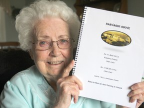 Seeleys Bay author Geraldine Chase holds up her copy of her new book, Harvards Above, which chronicles the history of the wartime airports in Kingston and Gananoque. MICHAEL LEA\THE WHIG-STANDARD