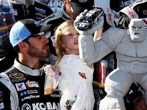 Jimmie Johnson and his daughter Genevieve Marie look at the Miles The Monster Trophy after winning the NASCAR Sprint Cup Series FedEx 400 Benefiting Autism Speaks at Dover International Speedway in Dover, Del, yesterday. (AFP)