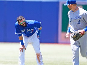 Alex Gordon of the Royals checks on Blue Jays’ Jose Bautista, who hurt his leg sliding into third base during the second inning Sunday at the Rogers Centre. (Michael Peake, Toronto Sun)