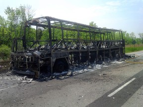 The remains of a bus carrying seniors from Toronto to Ottawa is pictured on the side of the eastbound 401 near Port Hope, Ont. on Monday June 2, 2014. All the passengers aboard got off safely. (Pete Fisher/QMI Agency)