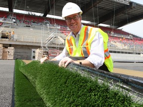 Mayor Jim Watson checks out the first roll of turf being laid on the field at TD Place Monday, June 2, 2014.
DOUG HEMPSTEAD/Ottawa Sun/QMI AGENCY