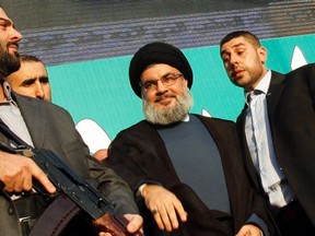 Lebanon's Hezbollah leader Sayyed Hassan Nasrallah (2nd R), escorted by his bodyguards, greets his supporters at an anti-U.S. protest in Beirut's southern suburbs September 17, 2012. (REUTERS/Sharif Karim)