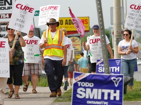 About 30 members of Canadian Union of Local Employees (CUPE) from Local 1022 Hastings and Prince Edward District School Board and Local 1479 Algonquin and Lakeshore Catholic District School Board rally in front of MPP Todd Smith's Belleville, Ont. campaign office on North Front Street Monday afternoon, June 2, 2014. - Jerome Lessard/The Intelligencer/QMI Agency