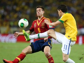 Spain's Cesar Azpilicueta (L) fights for the ball with Brazil's Oscar during their Confederations Cup final soccer match at the Estadio Maracana in Rio de Janeiro June 30, 2013. (REUTERS)