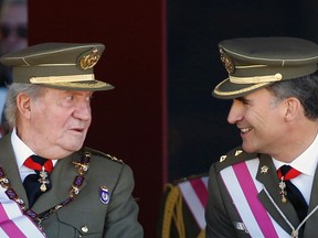 Spain's Crown Prince Felipe smiles next to his father King Juan Carlos (L).

REUTERS/Sergio Perez