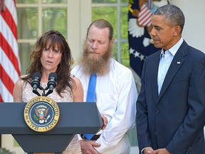 Freed American soldier Bowe Bergdahl's mother Jani Bergdahl (L) speeks to the press while his father Bob Bergdahl (C) and U.S. President Barack Obama look on in the Rose Garden of the White House on May 31, 2014. (AFP PHOTO/Mandel NGAN​)