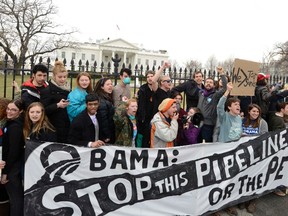 Environmentalists, many of whom have zip-tied themselves to the fence of the White House in Washington, rally and call on U.S. President Barack Obama to reject the Keystone XL pipeline in this March 2, 2014 file photo. (REUTERS/Mike Theiler/Files)