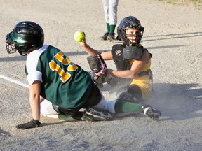 Kaya Keyser (right), catcher with the Mitchell Mite Girls #1 team, holds up the ball to show the umpire the tag she applied against Lucan during play last Thursday night at the four-day Fastballfest. ANDY BADER/MITCHELL ADVOCATE