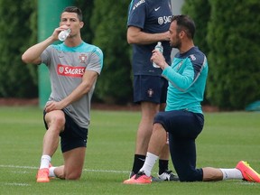 Cristiano Ronaldo (L) of Portugal's National Team rests after running laps with teammate Hugo Almeida as they practice for their upcoming friendly soccer matches in the United States. (REUTERS)