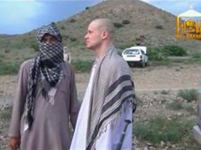 U.S. Army Sergeant Bowe Bergdahl (R) waits before being released at the Afghan border, in this still image from video released June 4, 2014. REUTERS/Al-Emara via Reuters TV
