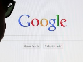 A computer user poses in front of a Google search page in this photo illustration taken in Brussels May 30, 2014.  REUTERS/Francois Lenoir