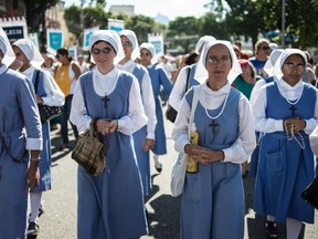 Catholic nuns take part in a procession --from Sao Sebastiao dos Capuchinhos church to the Metropolitan Cathedral-- to celebrate the day of Saint Sebastian, Rio de Janeiro's Patron Saint, in Rio de Janeiro, Brazil on January 20, 2014.  (AFP PHOTO / YASUYOSHI CHIBA)