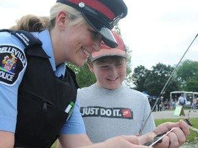 Special Cons. Diana Williams of Belleville police helps nine-year-old Matthew Findlay remove a fish from his hook during last year's annual Kids, Cops and Canadian Tire Fishing Derby.- Intelligencer file photo