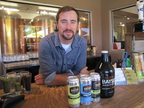 Bayside Brewing Company manager of retail and marketing Colin Chrysler poses with the four beers produced on site. From left: Lighthouse Light Lager, Long Pond Lager, Bronze Back dark ale and Honey Cream ale.
