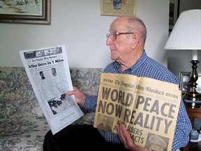 Ted McCue looks at an original Whig-Standard page and a print from D-Day and the Second World War at his home in Kingston. McCue died recently at the age of 87. Patrick Kennedy/Whig-Standard file photo