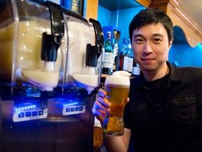 Co-owner Jimmy Lee tops a pint with frozen beer Thursday behind the bar at the Poacher?s Arms on Richmond St.   (CRAIG GLOVER, The London Free Press)