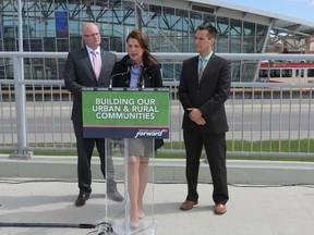 Wildrose leader Danielle Smith speaks to media with Jeff Wilson, left, and Rob Anderson at the Crowfoot LRT station in Calgary, Alta., on Thursday June 5, 2014. Mike Drew/Calgary Sun/QMI Agency