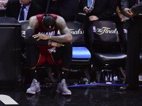 Miami Heat forward LeBron James in pain on the bench during Game 1 of the NBA Finals against the San Antonio Spurs at the AT&T Center in San Antonio, June 5, 2014. (BOB DONNAN/USA Today)