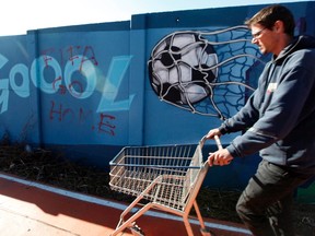 A man walks past a graffiti referring to the World Cup with the sign "FIFA go home", in Sao Paulo June 3, 2014. (REUTERS/Paulo Whitaker)