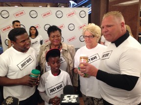Councillor Doug Ford, far right, standing next to his mom, Diane Ford, and  with Michael "Pinball" Clemons, far left, collecting donations for the Daily Bread Food Bank on June 6, 2014. (Don Peat/Toronto Sun)