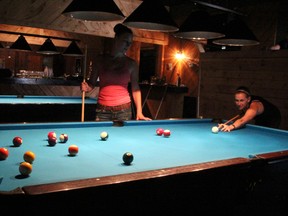 Bartenders Krystal French, left, and Alex Viglasky, try out one of the new pool tables at the revamped Rustic. The former Stubborn Mule location has been rebranded and reopened this week. (TYLER KULA, The Observer)