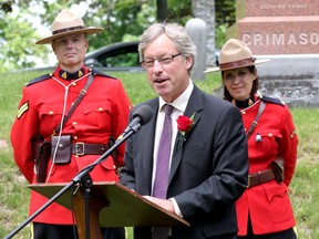 Historian and author John Boyko, flanked by two members of the RCMP, speaks during the service on Friday at Cataraqui Cemetery marking the death of Canada's first prime minister, Sir John A. Macdonald, on June 6, 1891. (Ian MacAlpine/The Whig-Standard)