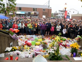 A crowd gathers around a makeshift memorial outside the RCMP building in Moncton. (QMI Agency)