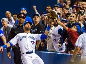 Toronto Blue Jays outfielder Jose Bautista is interfered with by a fan while tracking a pop up against the St. Louis Cardinals at the Rogers Centre in Toronto, June 6, 2014. (ERNEST DOROSZUK/QMI Agency)